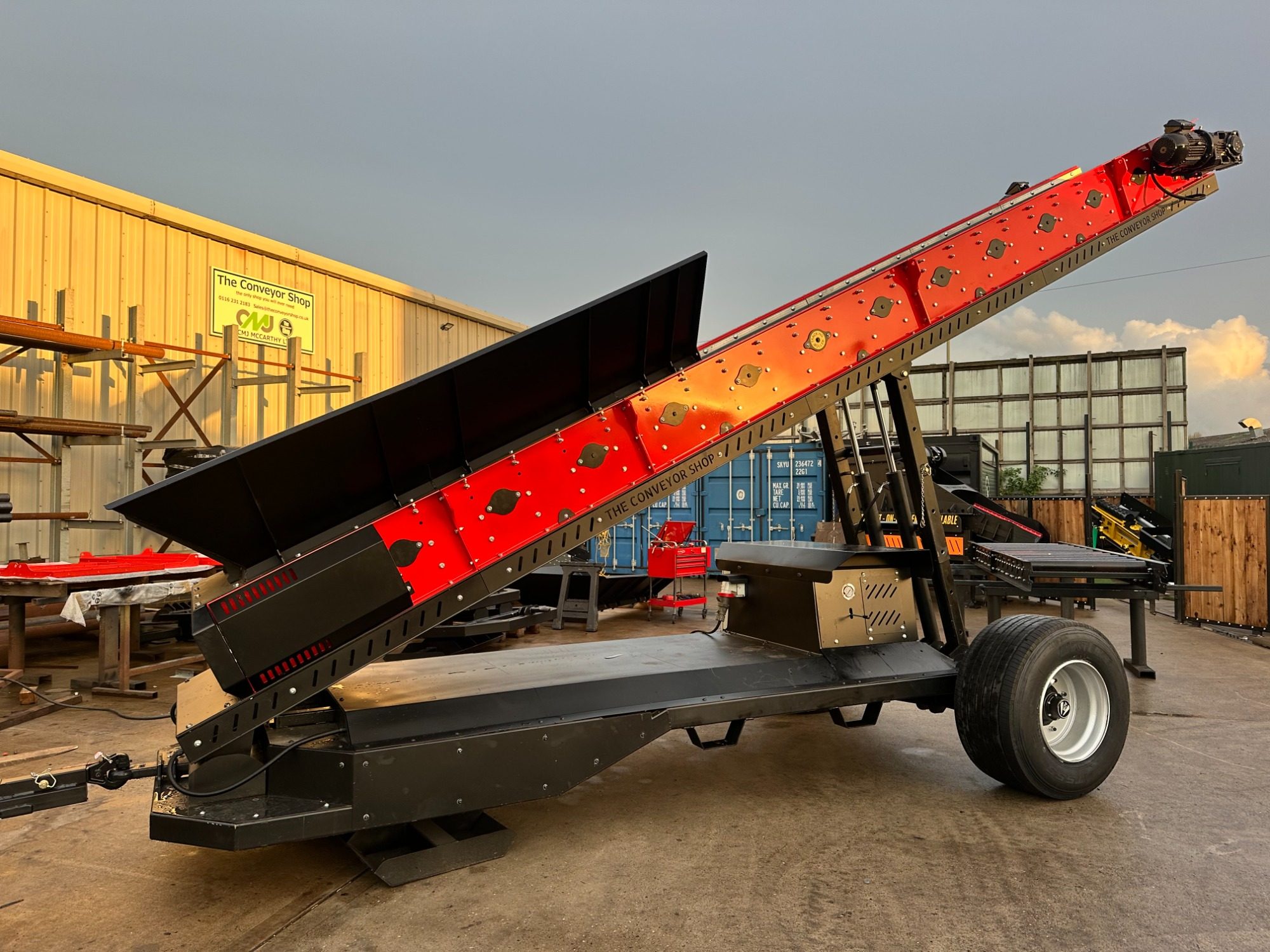 Recycling Conveyor Metal processing equipment with a series of cylindrical rollers mounted on a steel frame.