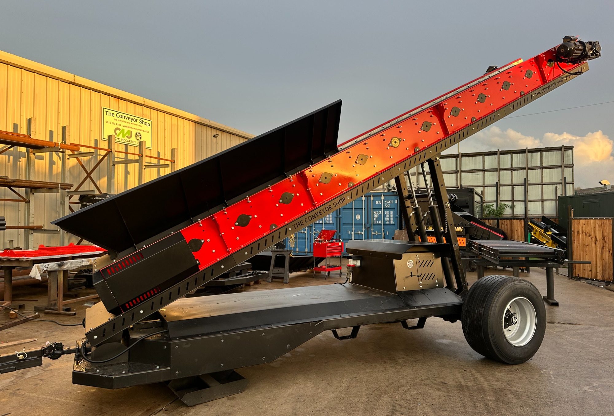 Recycling Conveyor Metal processing equipment with a series of cylindrical rollers mounted on a steel frame.